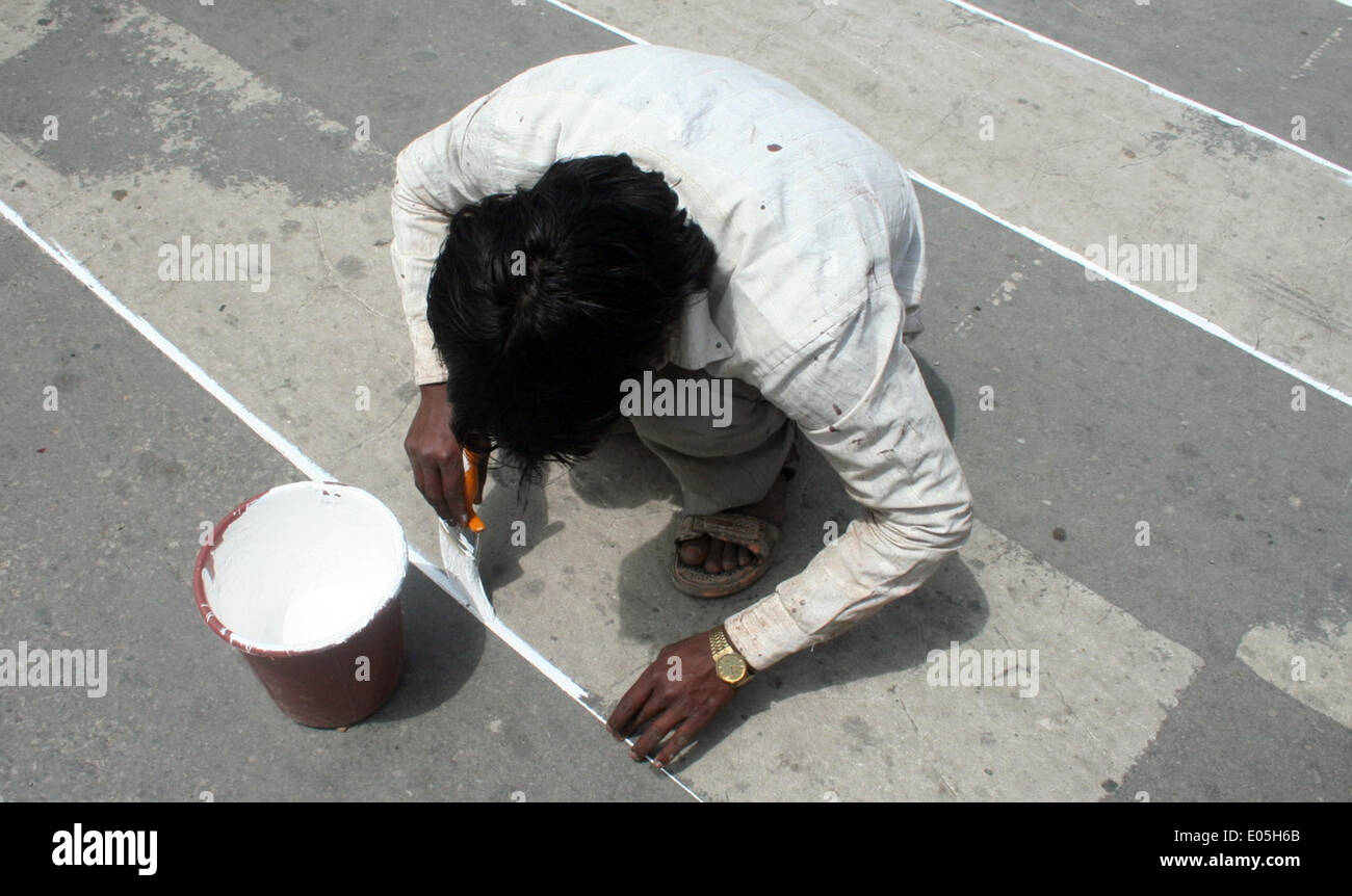 Srinagar, Indiano Kashmir amministrato. 03 Maggio 2014 : un non musulmani pittori pantaloni strade e sentieri pareti in srinagar durante l'apertura del 5 maggio questo mese ogni anno, segretariato civile, con circa 7.000 mployees, si muove a Srinagar in e estati a Jammu in inverni. Documenti ufficiali come migliaia di file vengono trasportati in autobus e camion su 300 km Jammu-Srinagar lungo l'autostrada nazionale. L'intero esercizio costi il cash-strapped membro a whopping 100 Rs crore ogni anno. un coprifuoco in corso. © sofi suhail/Alamy Live News Foto Stock