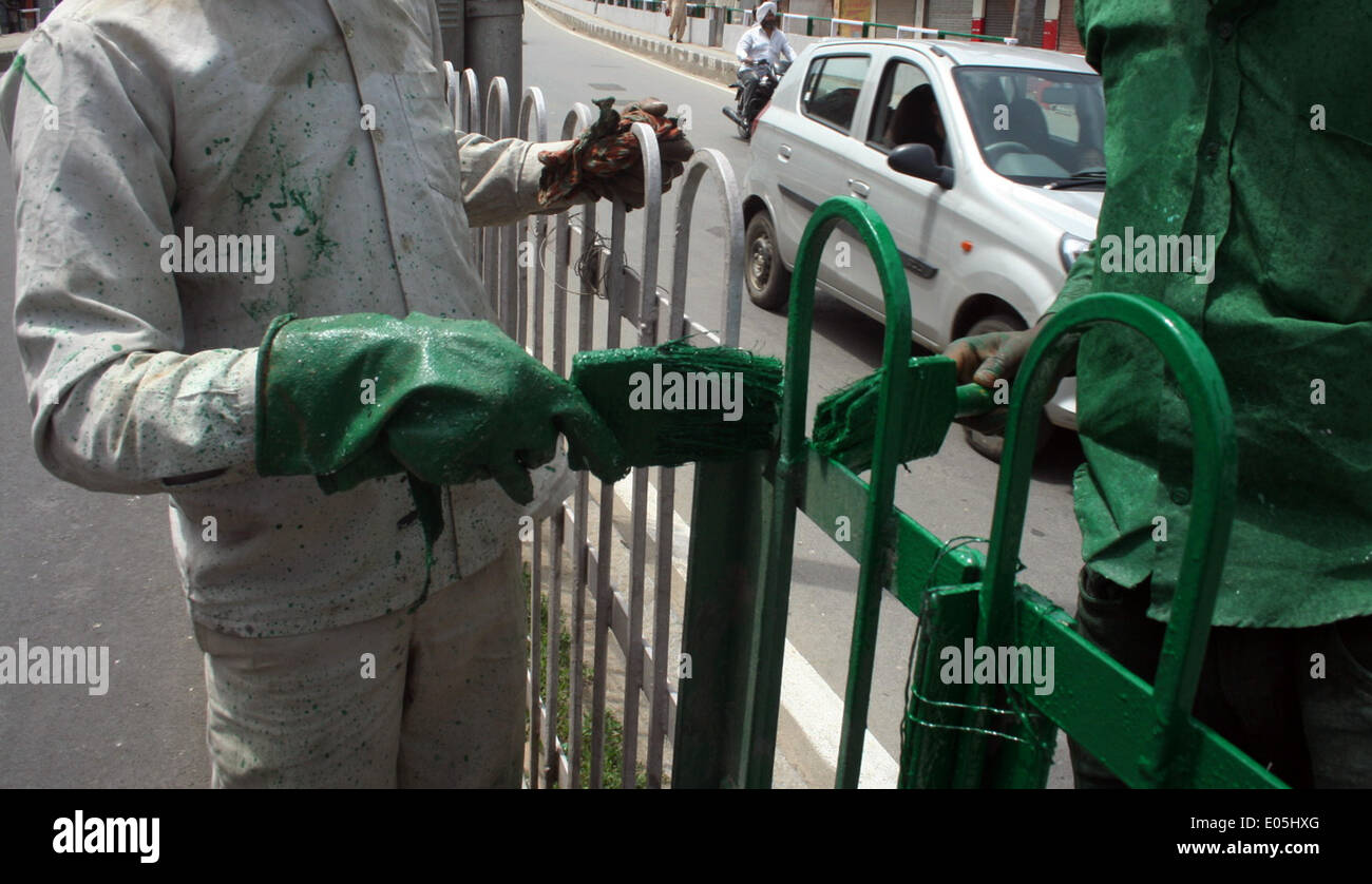 Srinagar, Indiano Kashmir amministrato. 03 Maggio 2014 : Non musulmani pittori pantaloni strade e sentieri pareti in srinagar durante l'apertura del 5 maggio questo mese ogni anno, segretariato civile, con circa 7.000 mployees, si muove a Srinagar in e estati a Jammu in inverni. Documenti ufficiali come migliaia di file vengono trasportati in autobus e camion su 300 km Jammu-Srinagar lungo l'autostrada nazionale. L'intero esercizio costi il cash-strapped membro a whopping 100 Rs crore ogni anno. un coprifuoco in corso. © sofi suhail/Alamy Live News Foto Stock