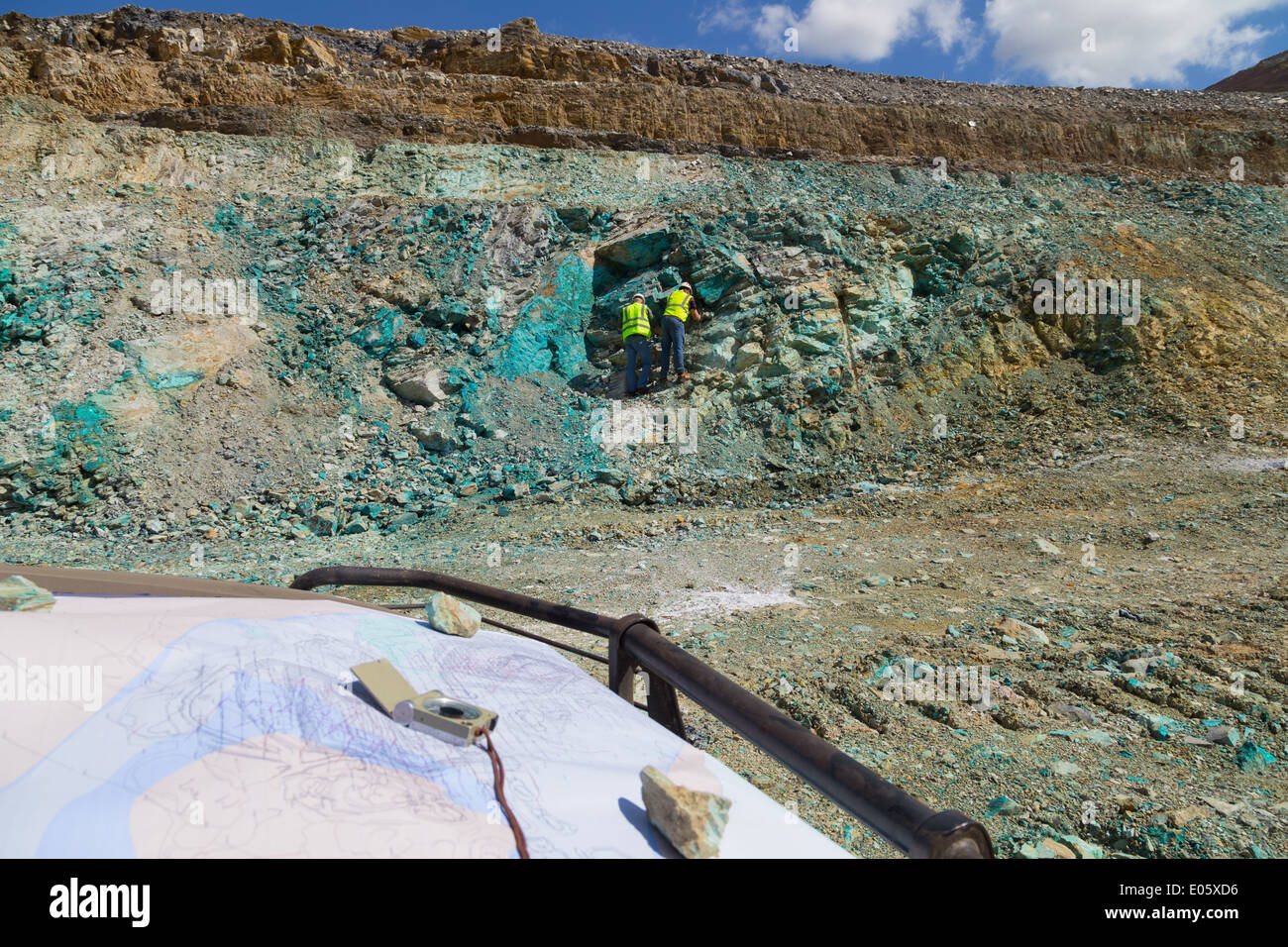 Due geologi ispezionare un affioramento di roccia contenente un sacco di minerale di rame in un massiccio a cielo aperto di rame e di miniera d'oro Foto Stock