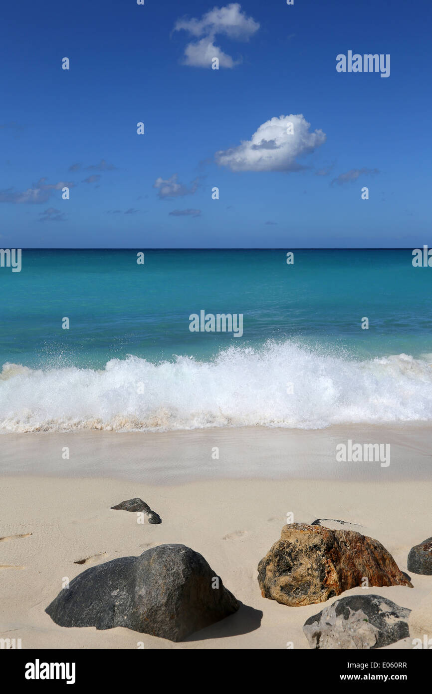 Spiaggia di sabbia nel Mar dei Caraibi con il mare e le onde, cielo blu e nuvole Foto Stock