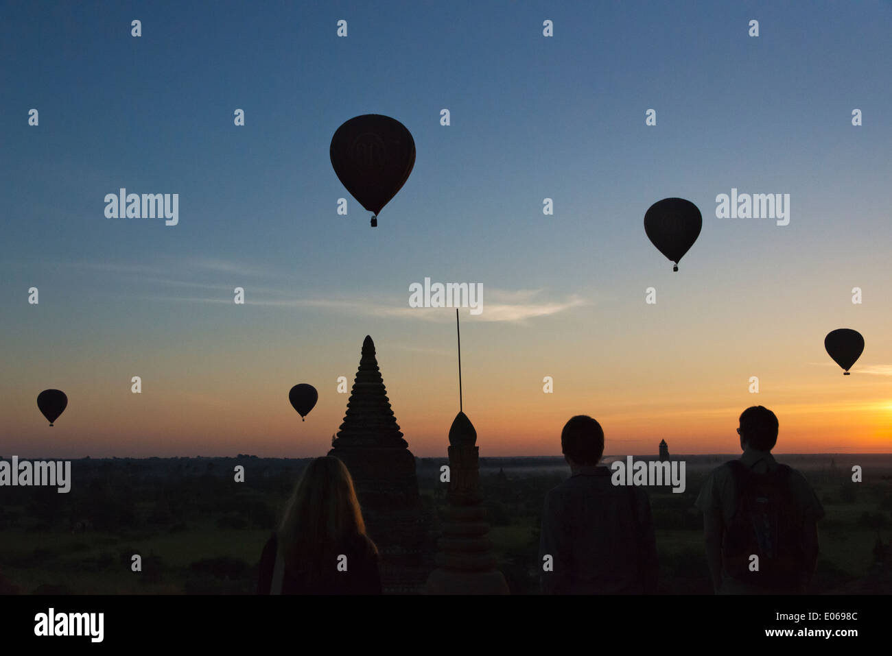 Tourist i palloni ad aria calda su antichi templi e pagode nella giungla di sunrise, Bagan, Myanmar Foto Stock
