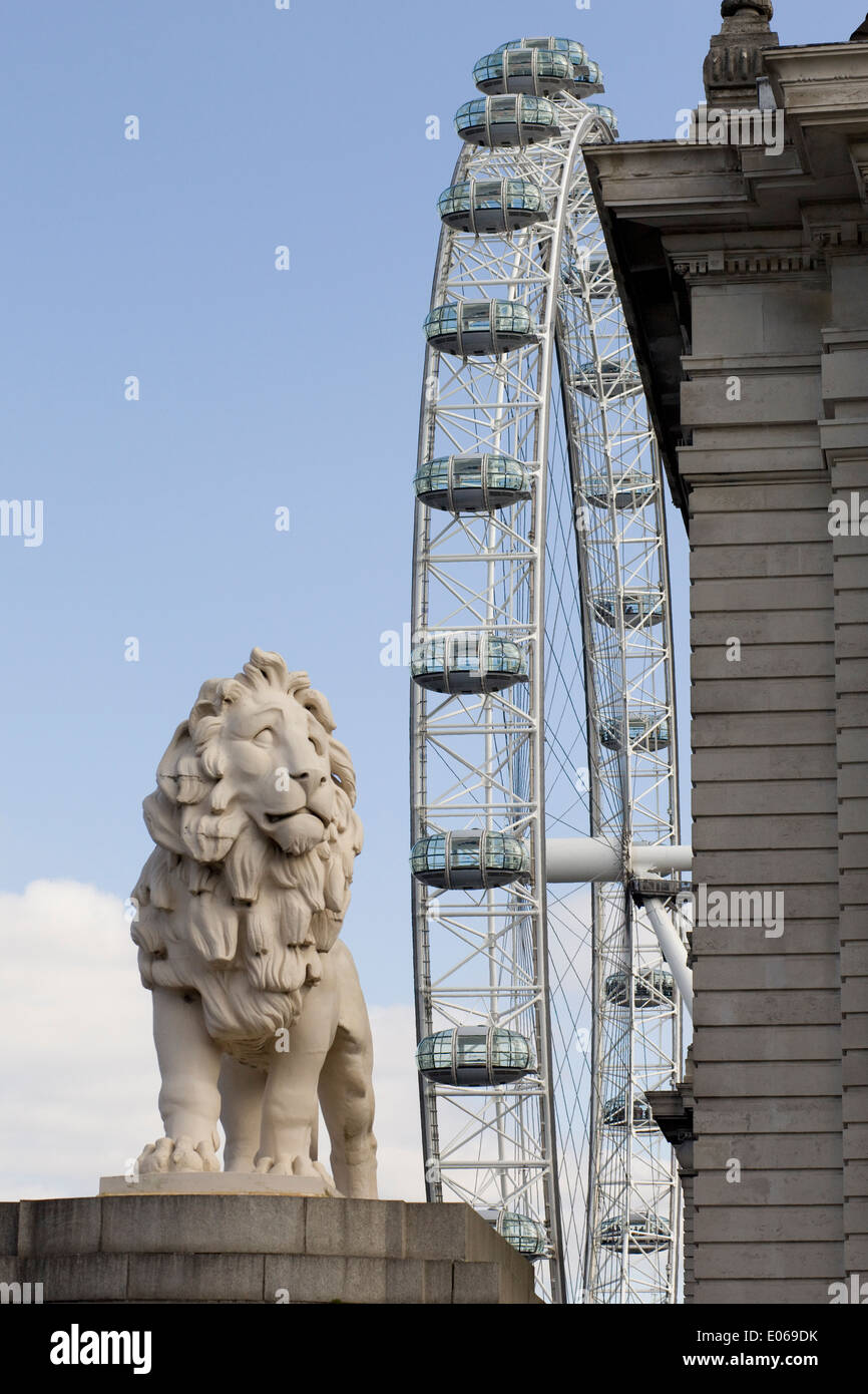 La Coade leone di pietra a guardia della estremità meridionale del Westminster Bridge con il London Eye sullo sfondo Inghilterra Foto Stock
