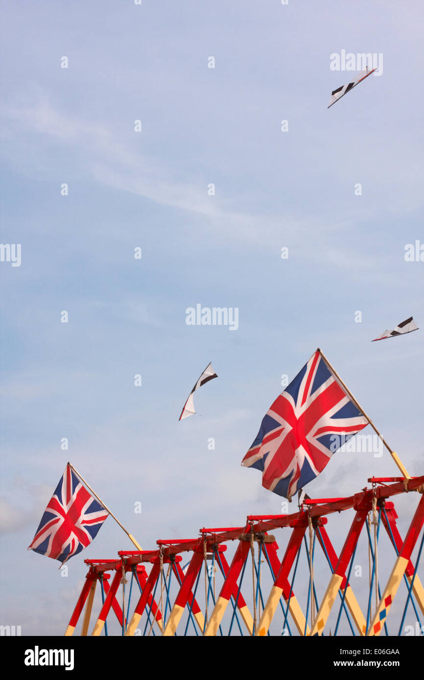 Weymouth, Regno Unito. 04th maggio, 2014. I visitatori si riuniscono per guardare la varietà di aquiloni colorati ballare con la musica nel cielo al Weymouth Kite Festival - aquiloni che volano sopra le bandiere di Union Jack sulle altalene altalene altalena altalena. Credit: Carolyn Jenkins/Alamy Live News Foto Stock