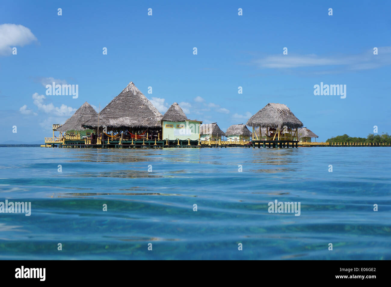 Tropical resort overwater con tetto di paglia visto dalla superficie di acqua, isola del colon, il mare dei Caraibi, Panama Foto Stock