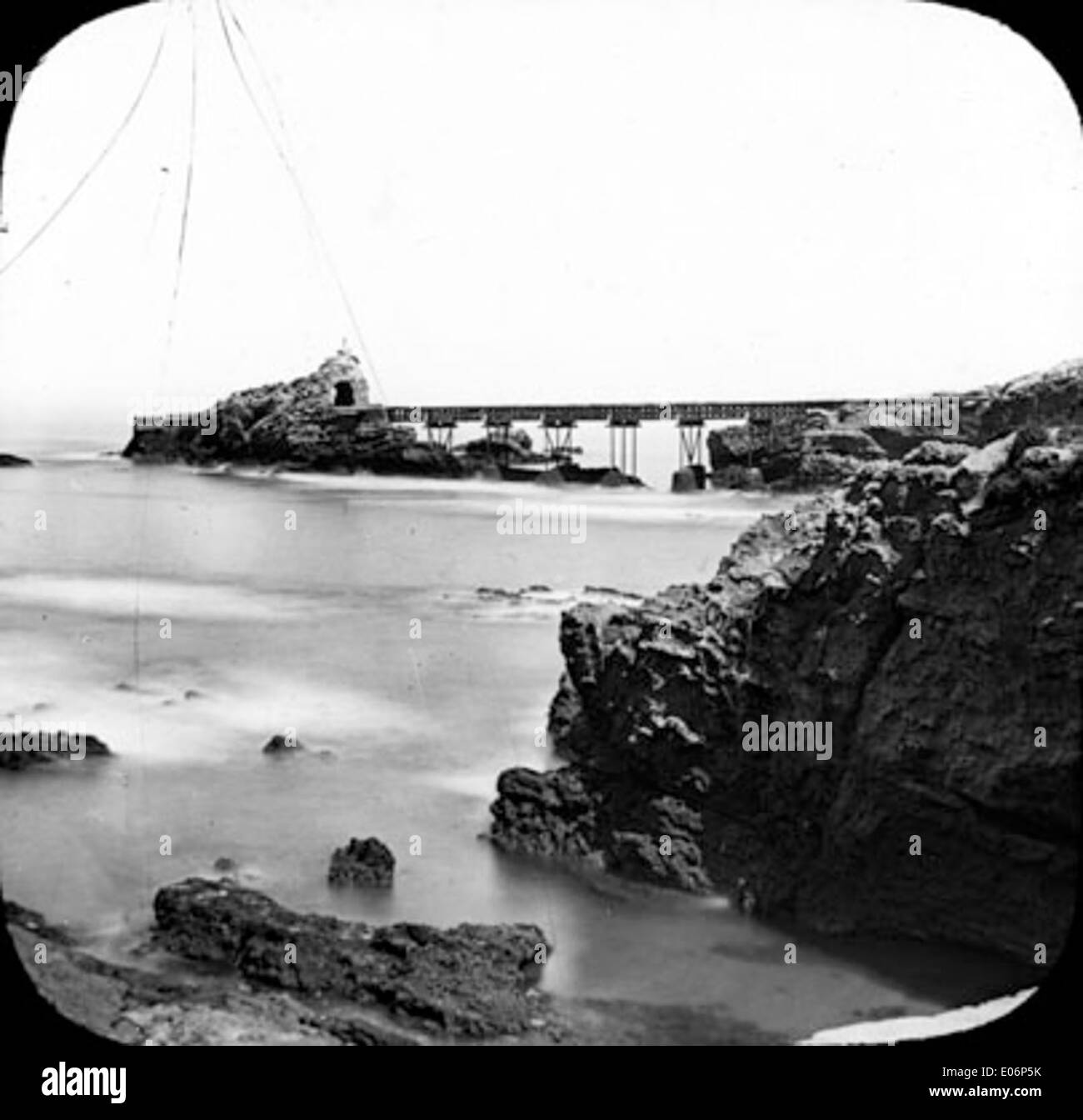 Una fotografia dell'iconico Rocher de la Vierge a Biarritz, che mostra la formazione rocciosa e il famoso ponte che vi conduce. L'immagine mette in risalto questo famoso monumento naturale lungo la costa basca. Foto Stock