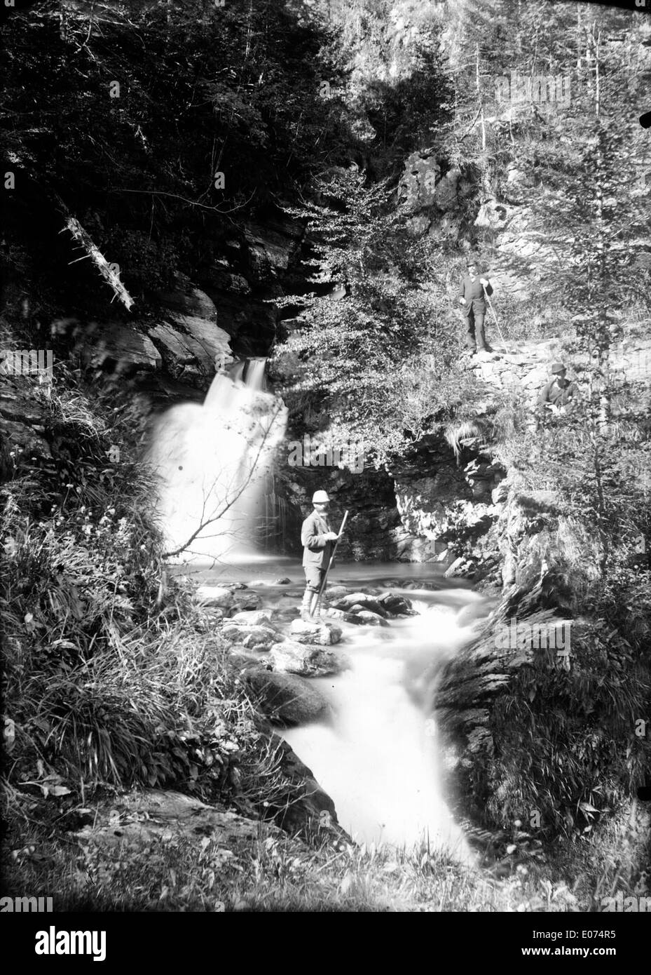 Una vista panoramica sulla cascata d'Enfer vicino a Luchon, che mostra il lussureggiante fogliame e gli alberi torreggianti che circondano l'area, una rappresentazione perfetta della bellezza naturale della regione. Foto Stock
