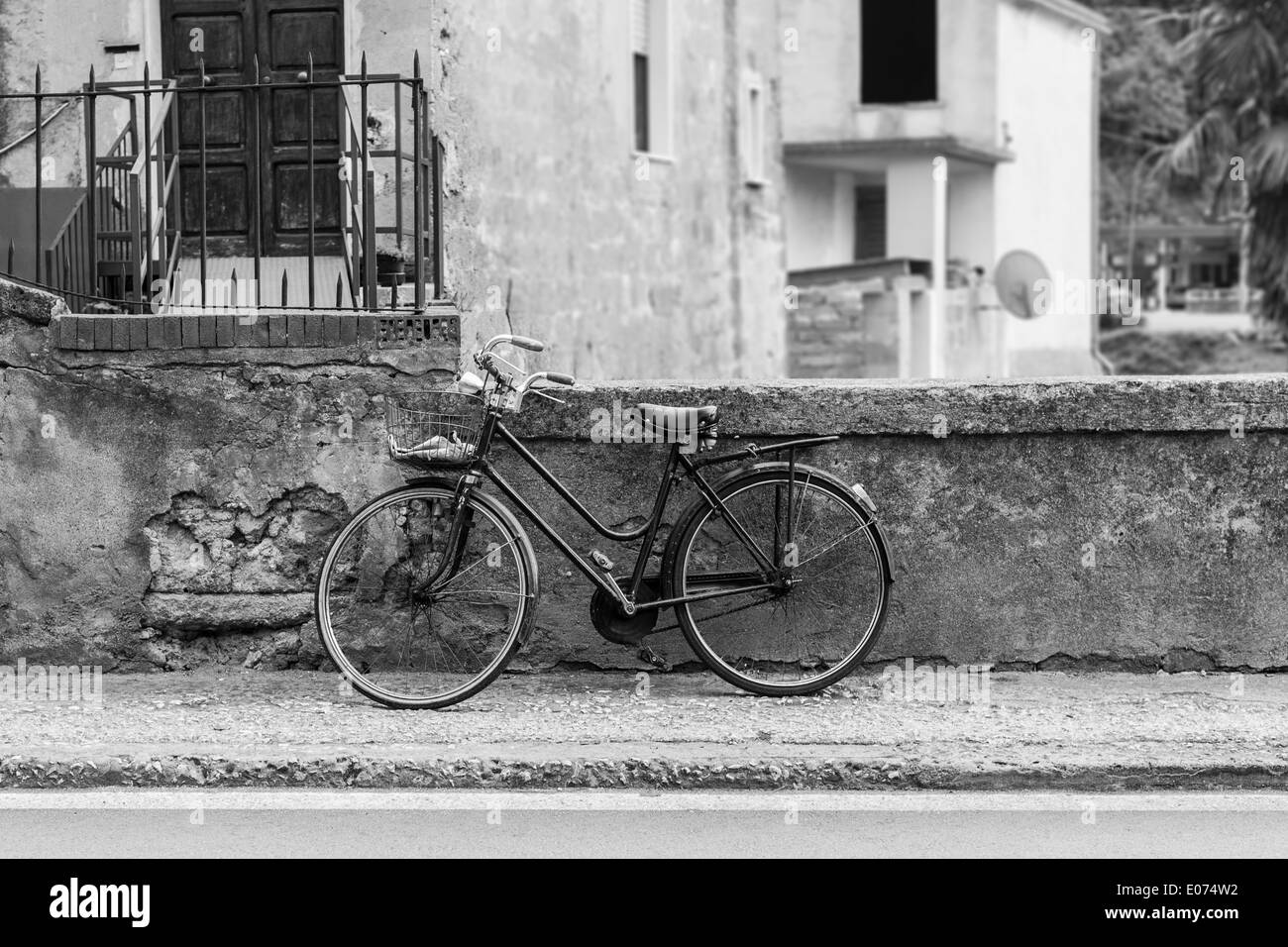 Una vecchia bicicletta parcheggiata in uno sporco vicolo italiano modo Foto Stock