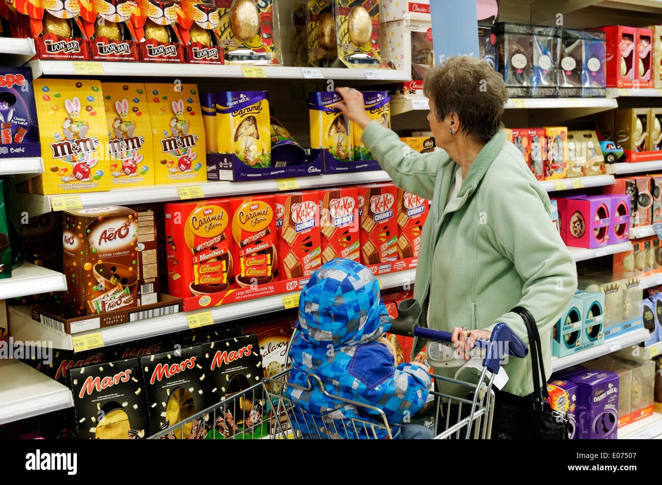 Nonna e nipote shopping per le uova di pasqua in Tesco Foto Stock