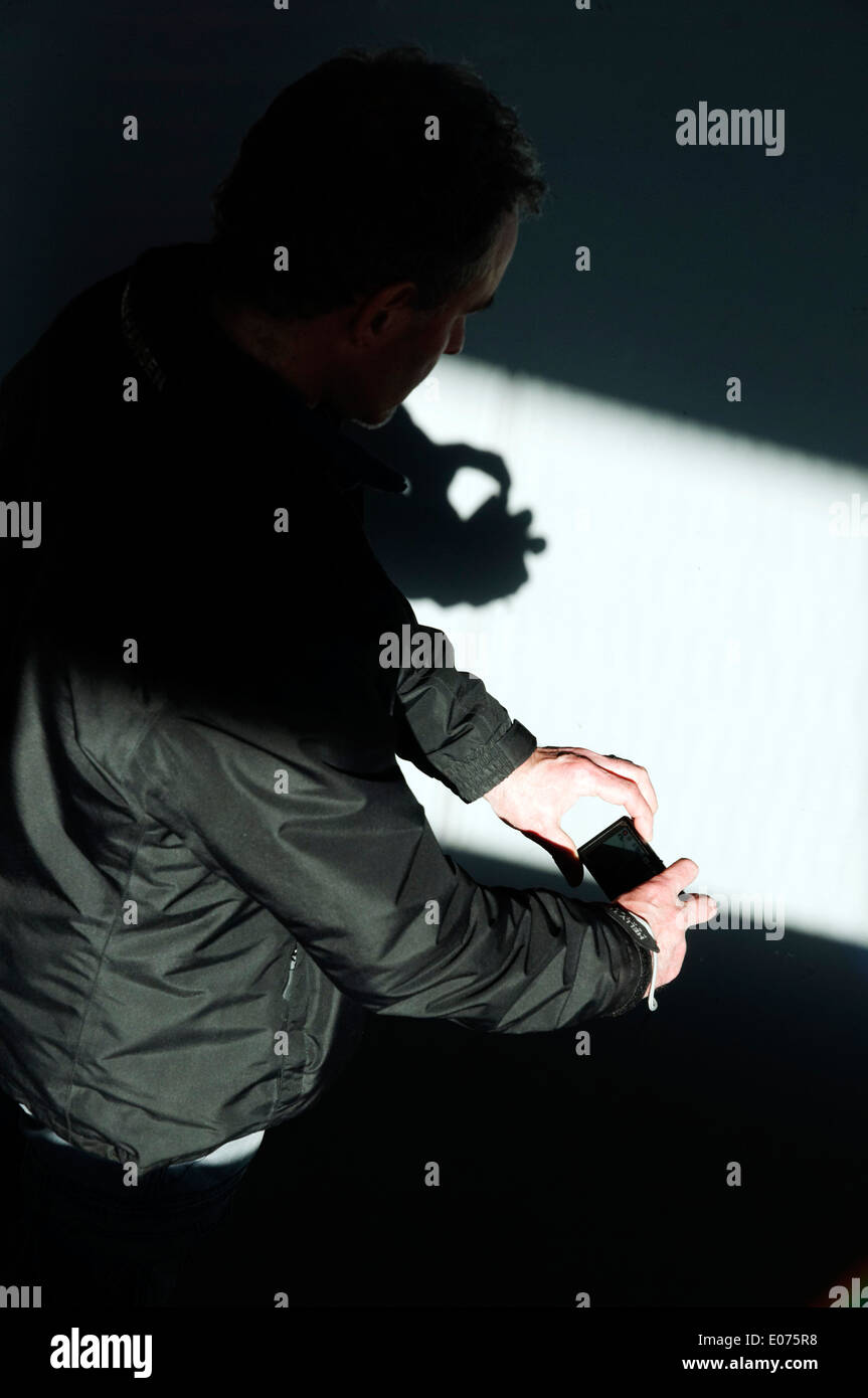 Ombra di un uomo con le mani in mano in possesso di una telecamera Foto Stock