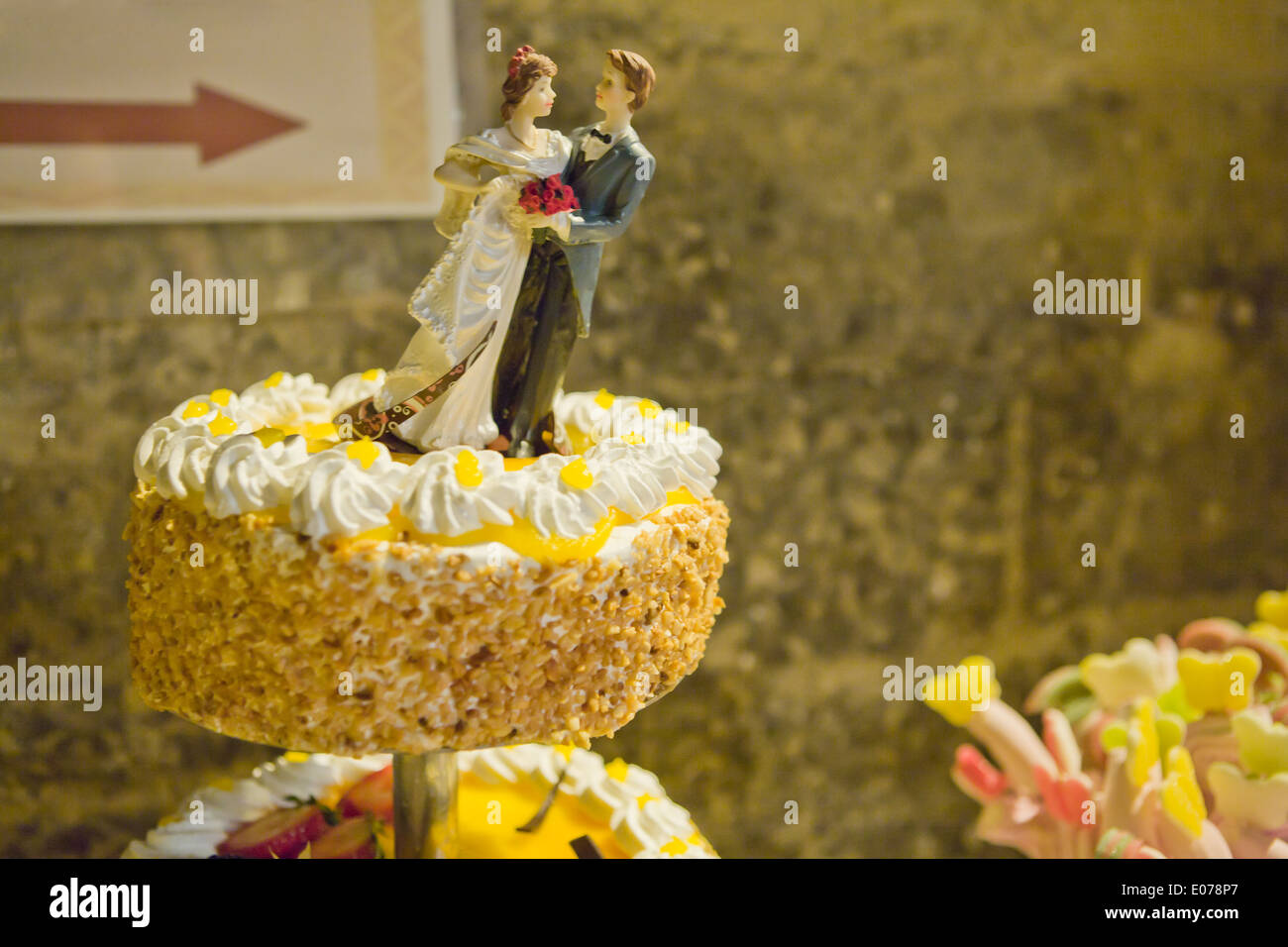 La sposa e lo sposo bambole su una torta di nozze cadere Foto Stock