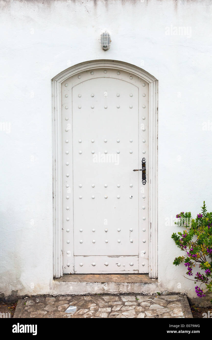 Muro Bianco e la vecchia porta di legno. Texture di sfondo Foto Stock