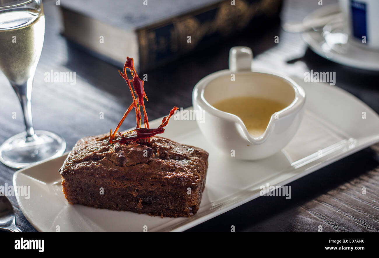 Speziato di zenzero mini focaccia servita con crema alla vaniglia e lo zucchero filato decorazione. Vino da dessert sul lato. Foto Stock