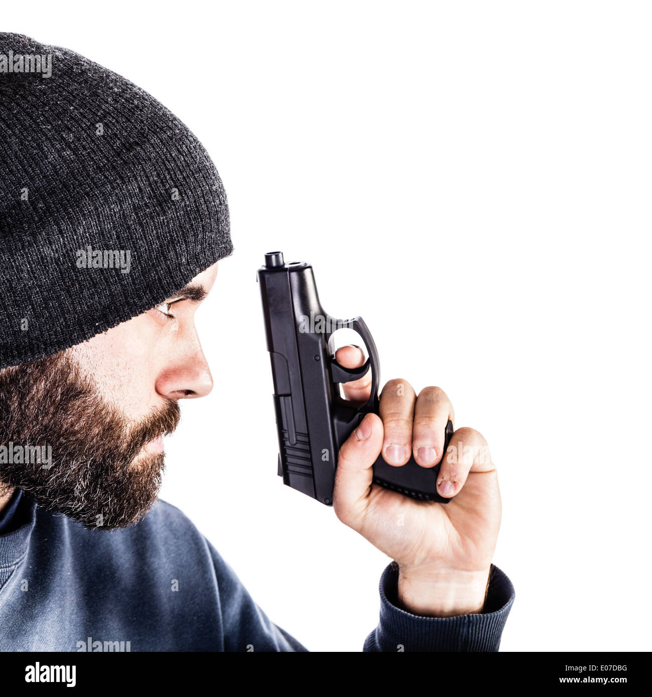 Un barbuto penale o un poliziotto in incognito con una pistola e indossando un beanie hat isolato su bianco Foto Stock