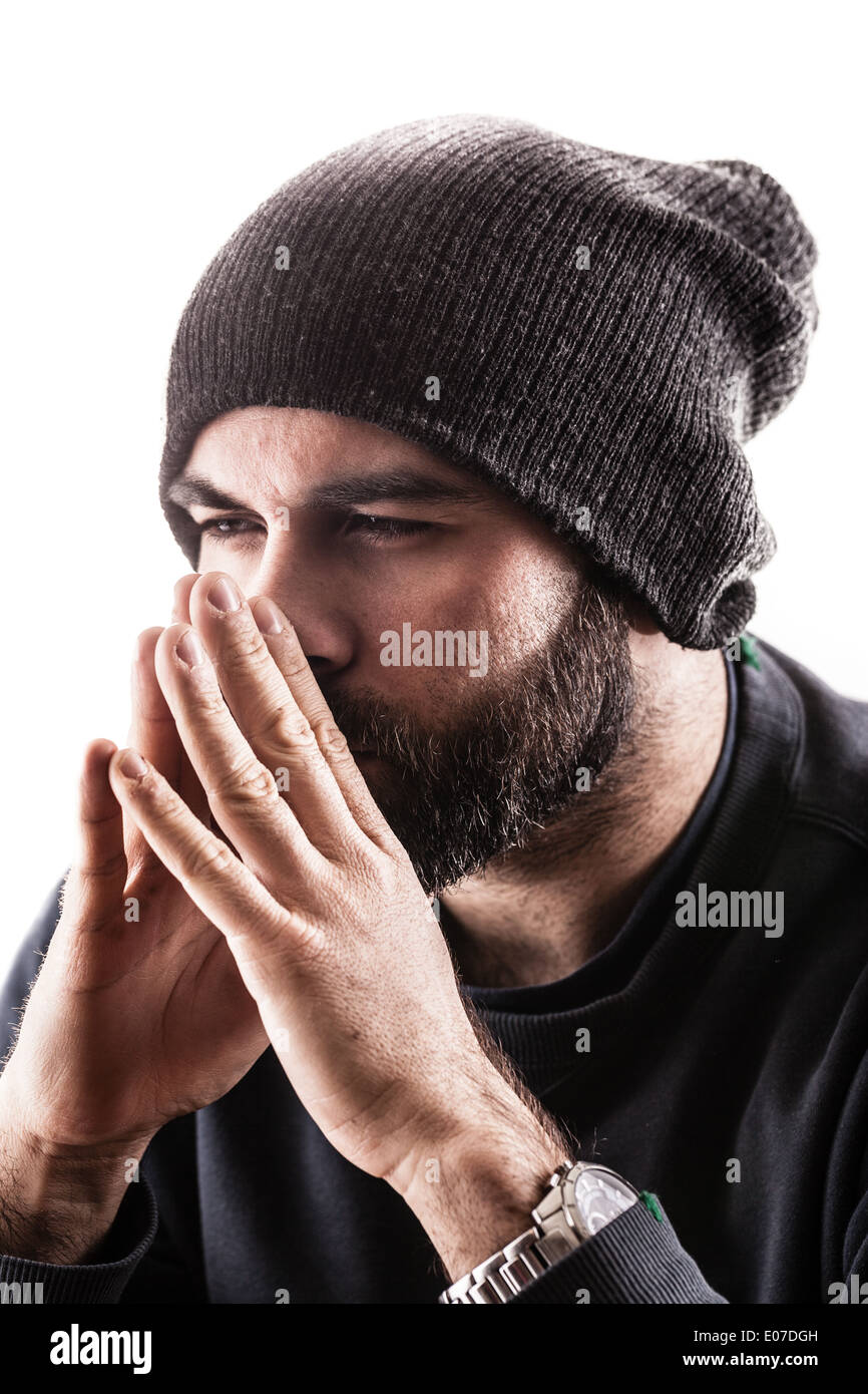 Ritratto di un uomo di pensiero con un beany e la barba, forse un rapper o un gangster Foto Stock