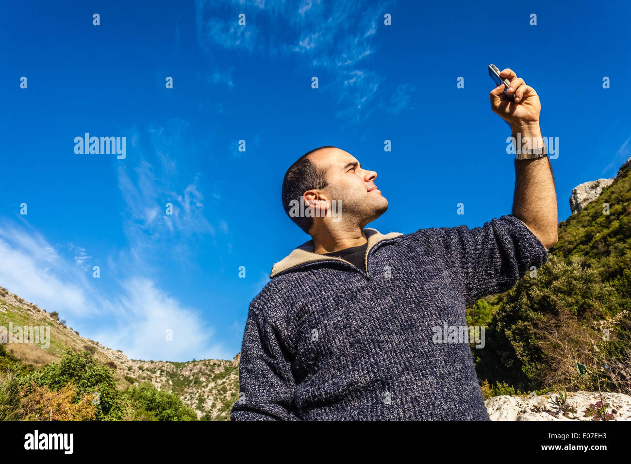 Un uomo cercando di captare il segnale sul suo telefono cellulare Foto Stock