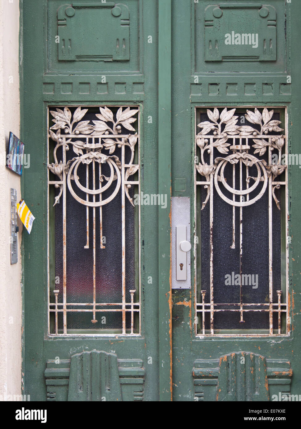 Il verde porta di ingresso con riempimenti di vetro bianco e ferro battuto decorazione, nota adesiva sul campanello, Vienna Austria Foto Stock