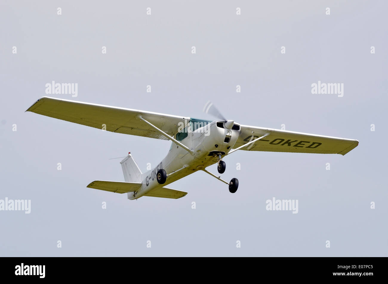 Cessna 150L ala alta monoplan aeromobili leggeri esce fuori dopo il decollo dalla Popham Airfield, Hamsphire, Inghilterra Foto Stock