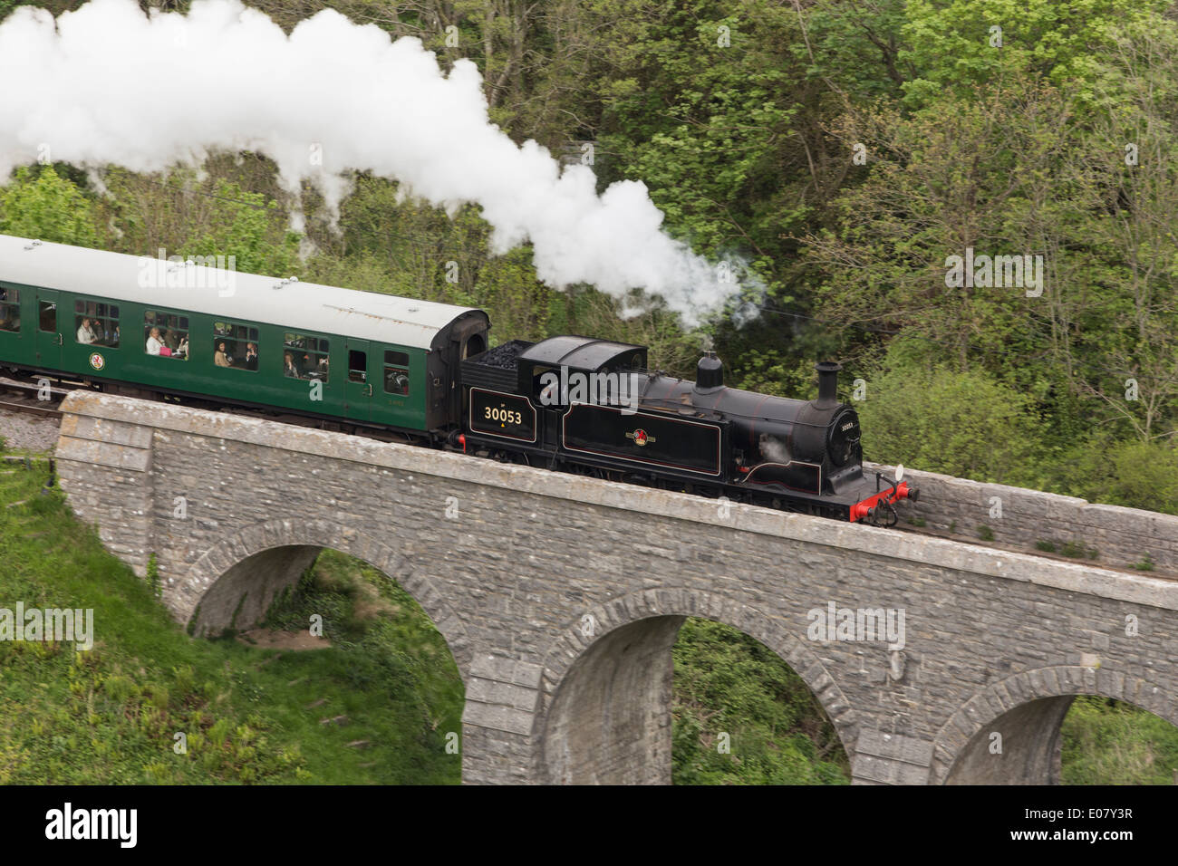 Treno a vapore tirando carrelli - viaggiando attraverso un ponte in Corfe Castle, Purbeck Hills, Dorset Foto Stock