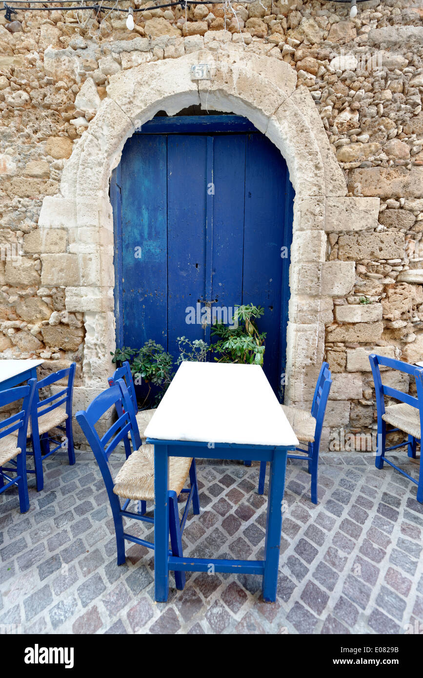 Taverna blu bianco tavolo con sedie in legno di colore blu porta con arco di pietra Chania old town Creta Grecia situato sul Foto Stock