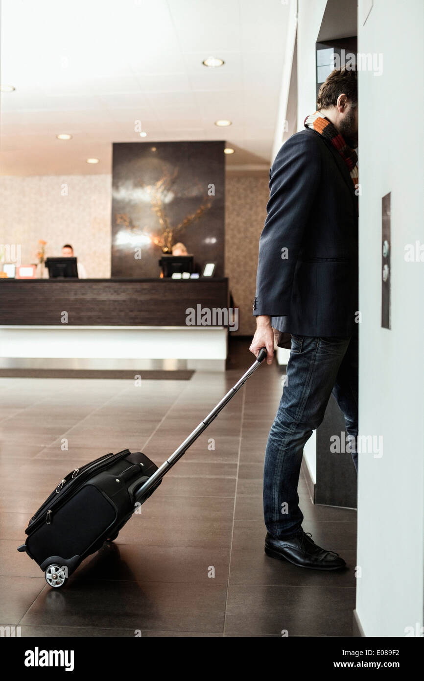 Imprenditore con bagagli entrando in ascensore in hotel Foto Stock