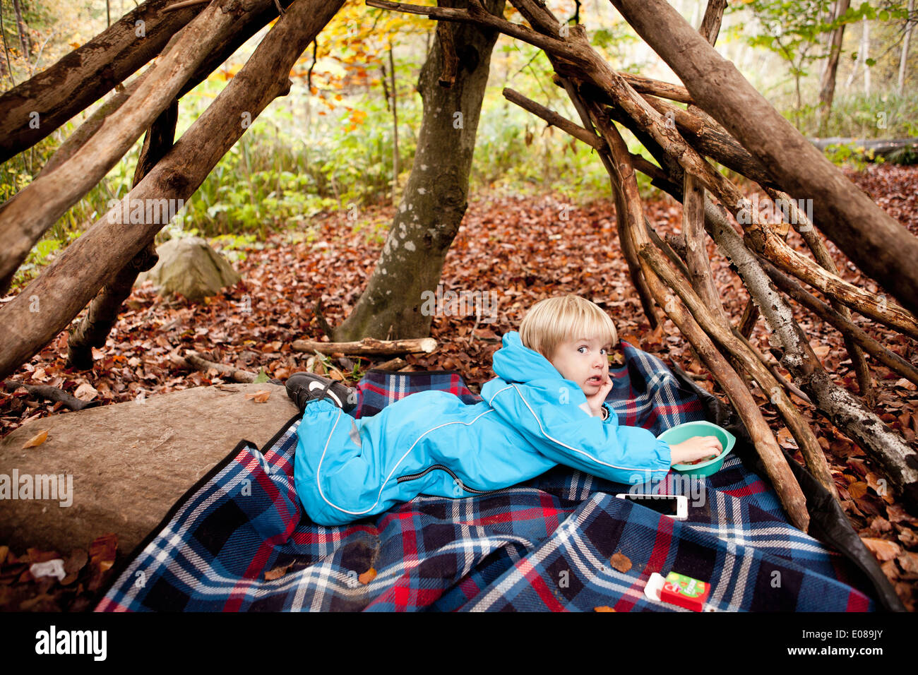 A piena lunghezza Ritratto di ragazzo disteso sulla coperta picnic in foresta Foto Stock