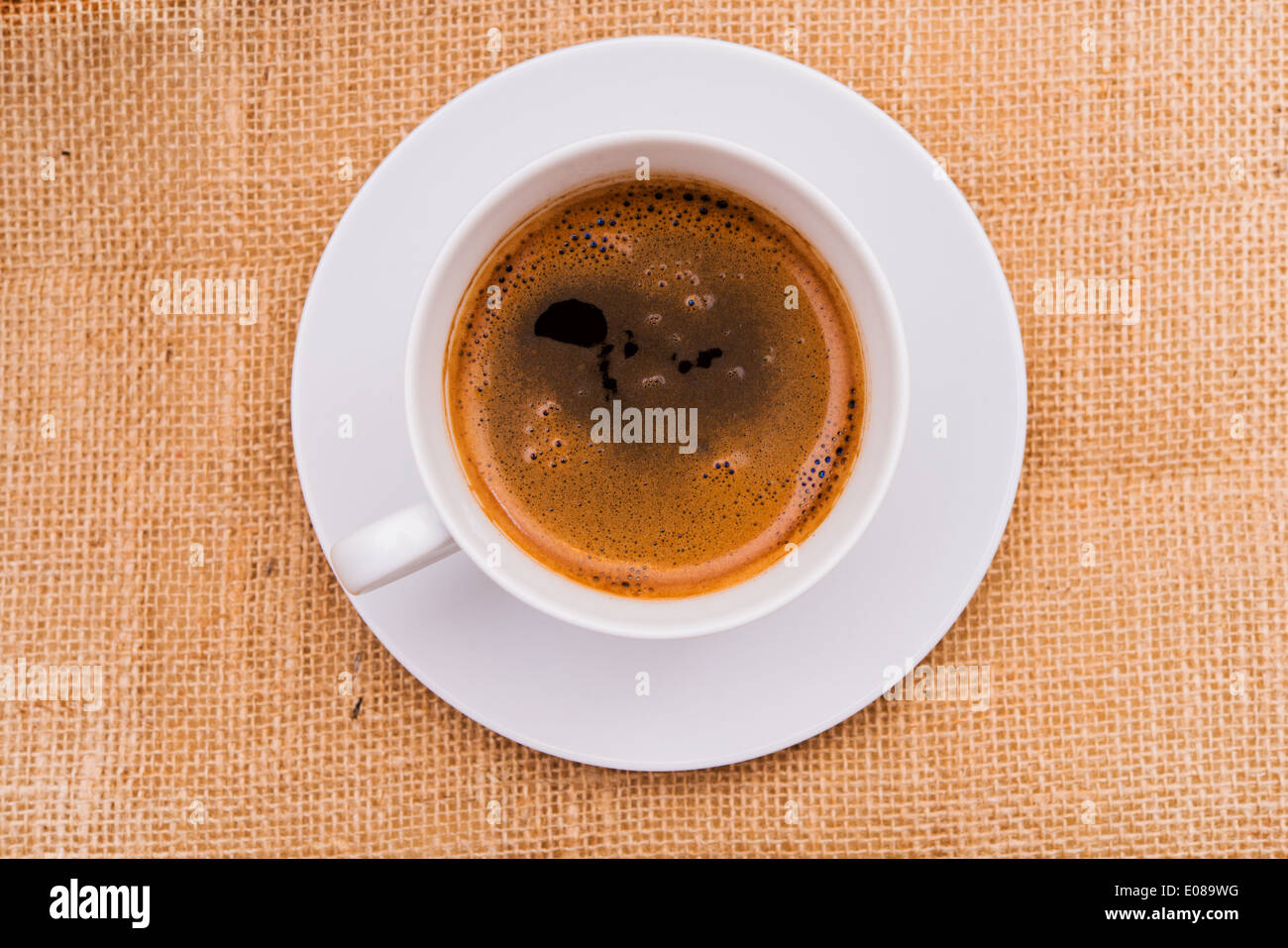 White tazza di caffè con caffè caldo su tela. Vista dall'alto. Foto Stock
