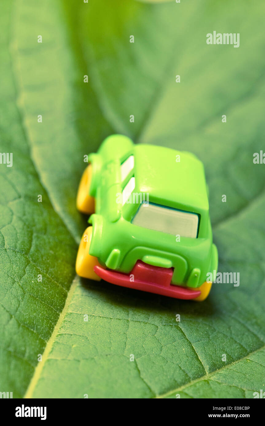 Piccolo verde giocattolo auto su una foglia verde auto concept Foto Stock