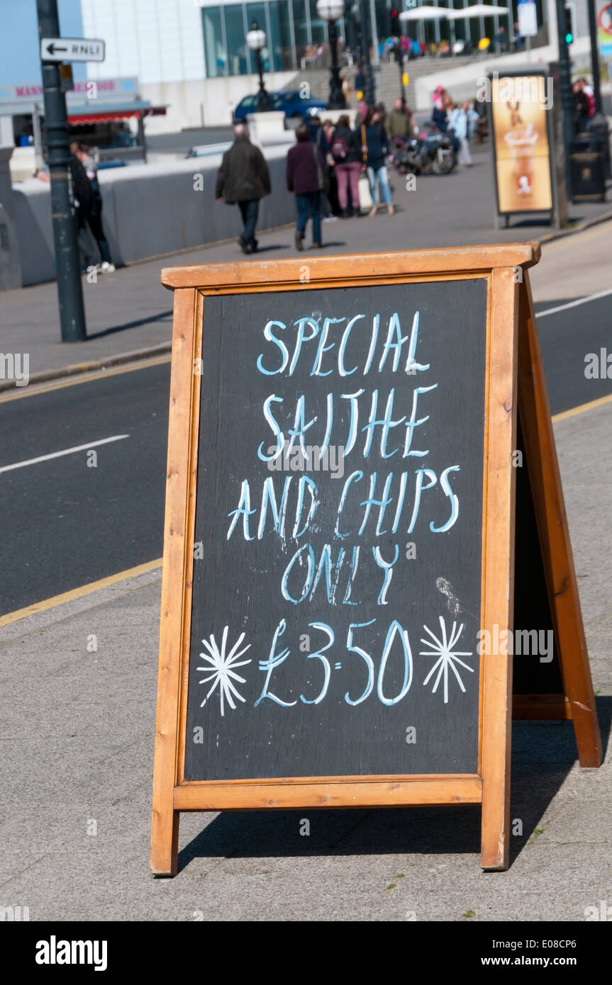 Un segno per il merluzzo carbonaro e trucioli al di fuori di un pesce e chip shop in Margate. Merluzzo carbonaro è un pesce sostenibile. Foto Stock