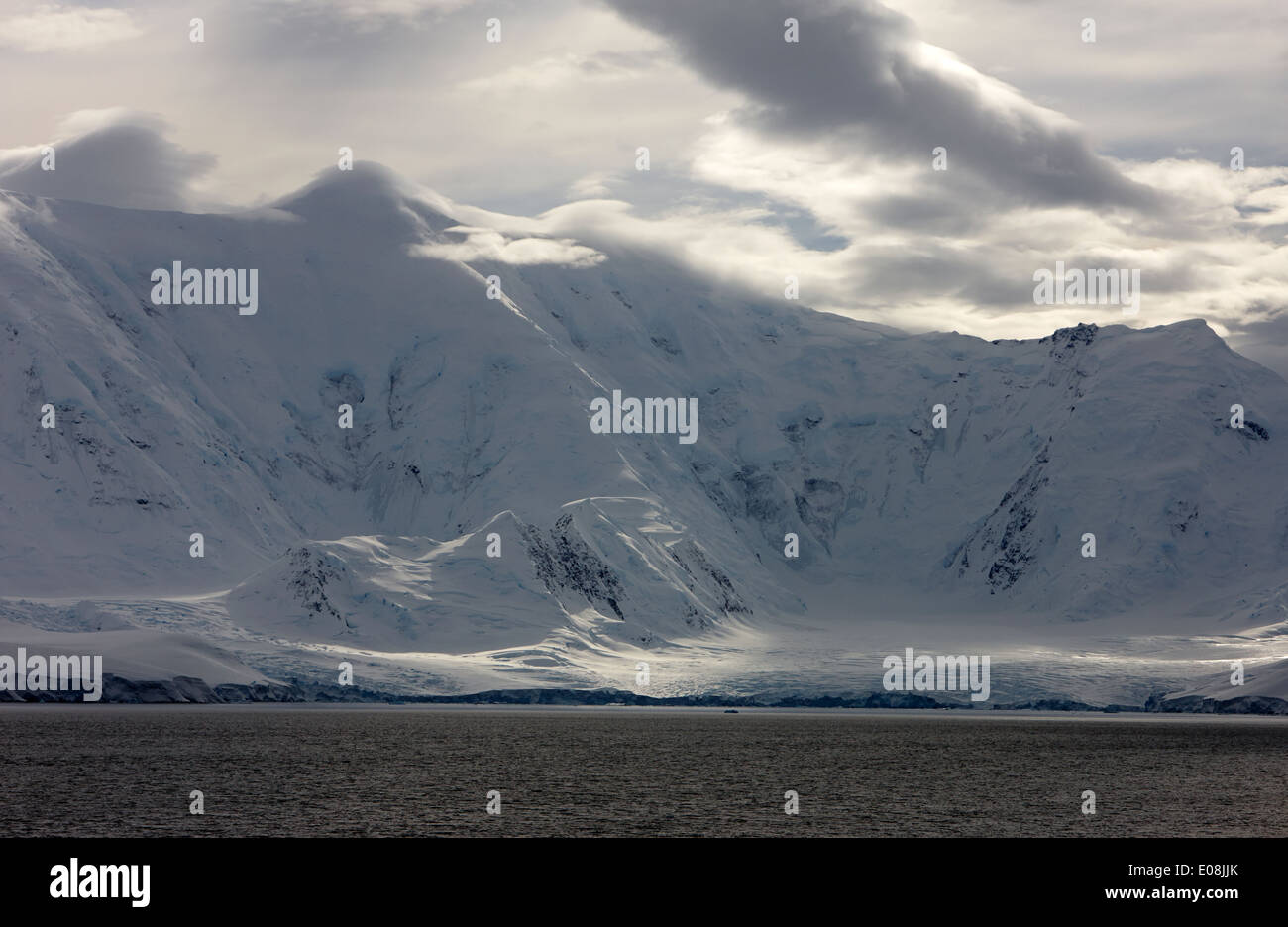 Rompendo la luce del sole attraverso le nuvole su paesaggi innevati di anvers island e canale neumayer Antartide Foto Stock