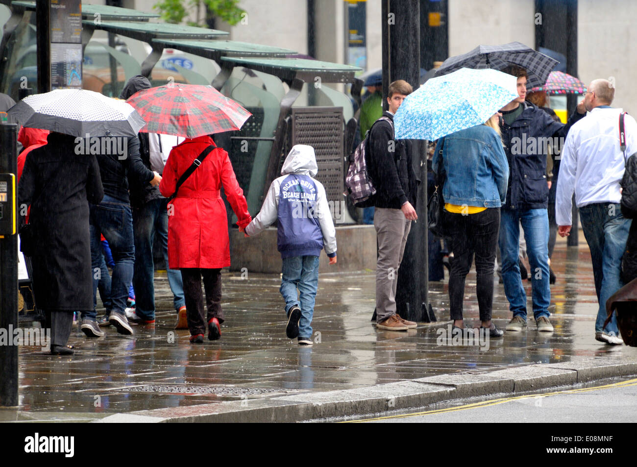 Londra, Inghilterra, Regno Unito. La gente camminare sotto la pioggia con ombrelloni Foto Stock