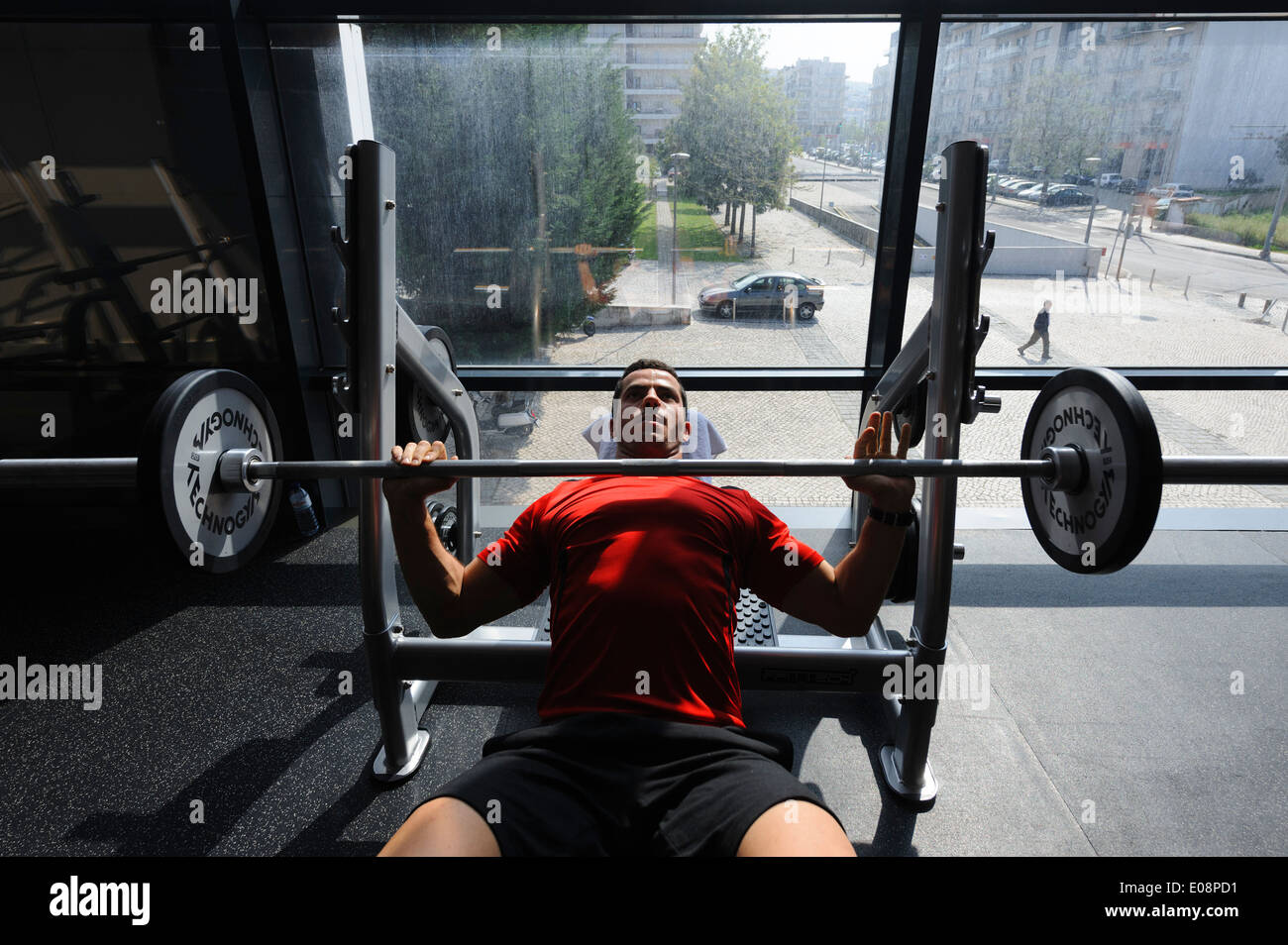 L'uomo facendo la pressa da banco esercizi in palestra Foto Stock