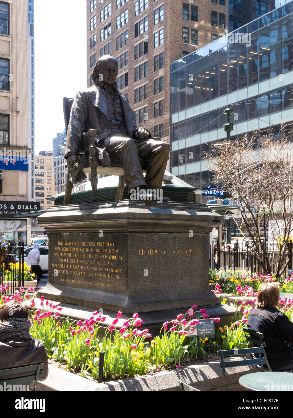 Statua di Horace Greeley con fiori di primavera, Greeley Square, New York, Stati Uniti d'America Foto Stock