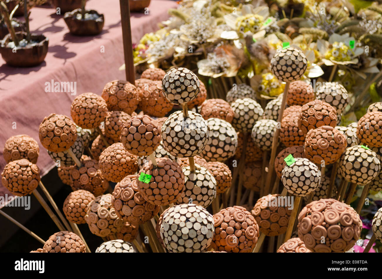 In legno fatti a mano e le sfere di argilla ornamenti su bastoni presso il village fair Foto Stock