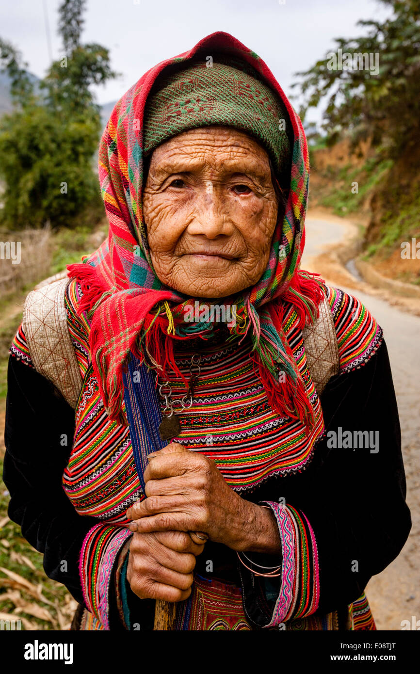 Una donna anziana dal fiore collina Hmong tribù sul suo modo al mercato settimanale può cau, Lao Cai Provincia, Vietnam Foto Stock