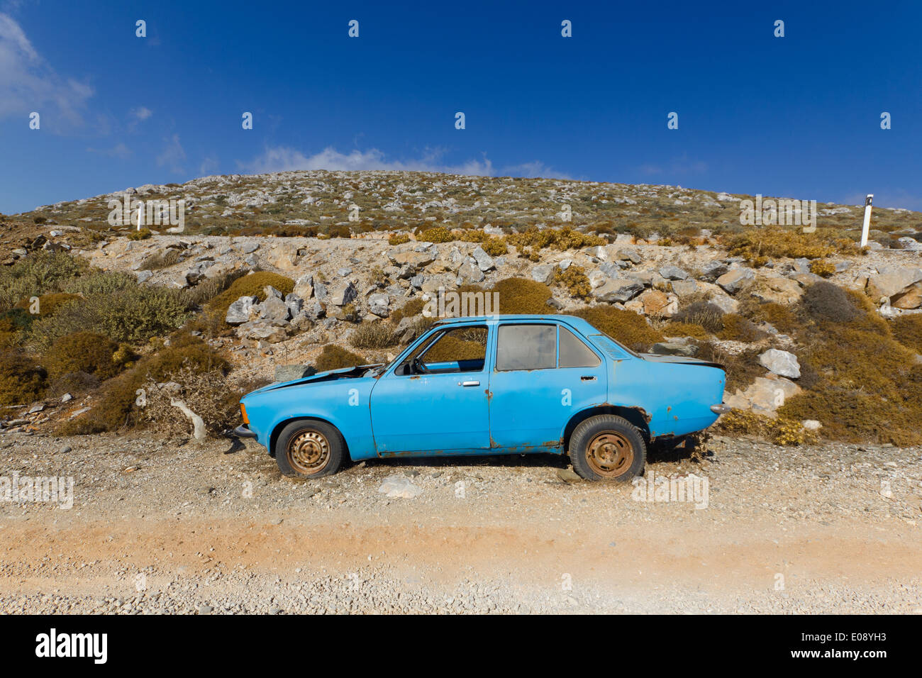 Abbandonato auto blu sulla strada di ghiaia Foto Stock