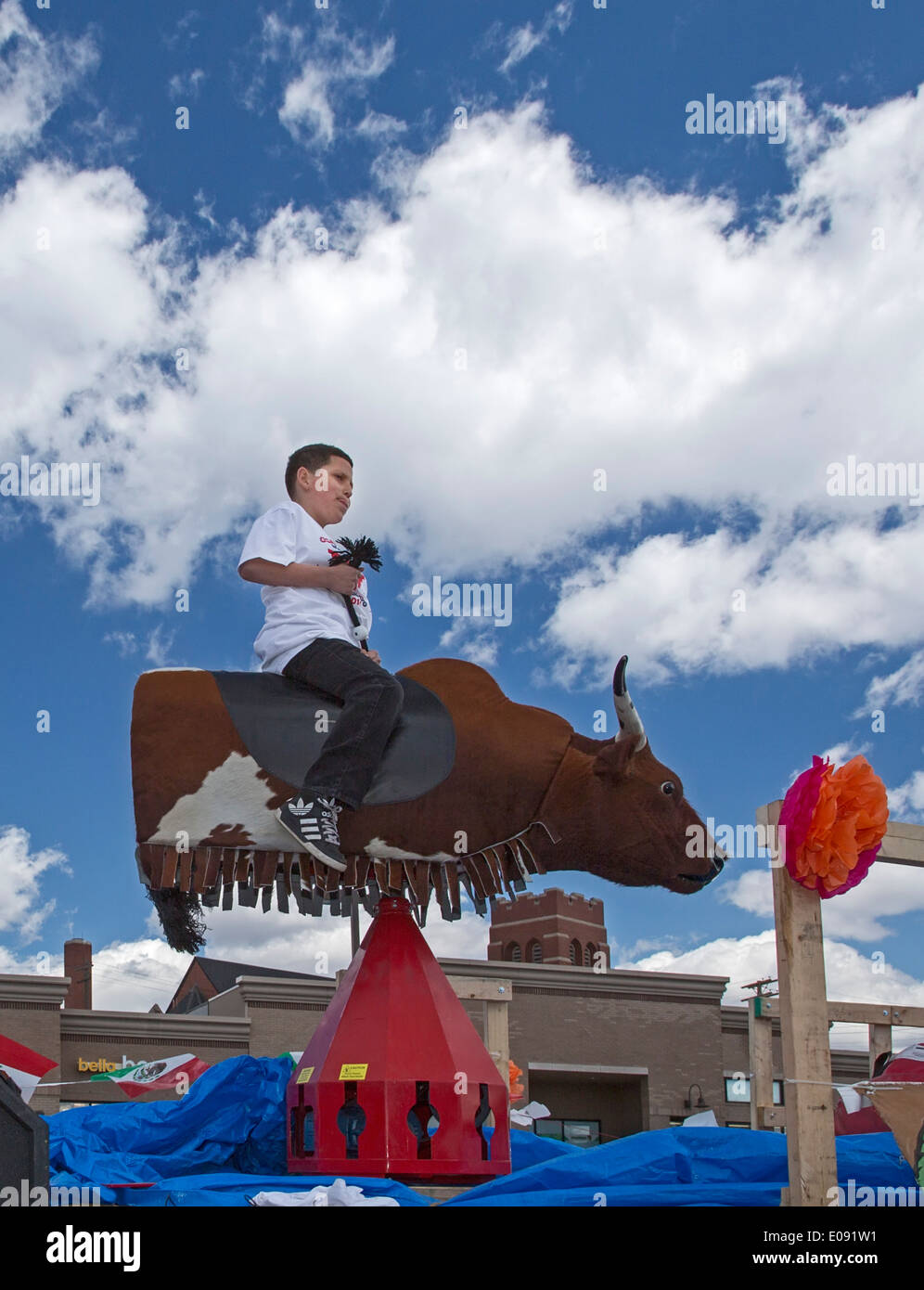Detroit, Michigan - Un ragazzo cavalca un toro meccanico durante l annuale Cinco de Mayo parade Foto Stock