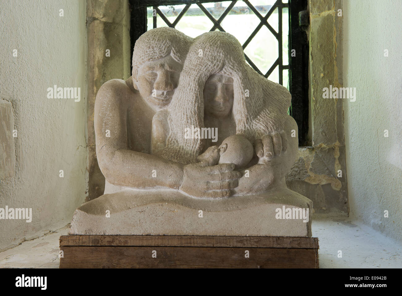 Figure scolpite che rappresentano la famiglia nella chiesa di San Michele e Tutti gli Angeli, Berwick, East Sussex, Regno Unito. Foto Stock