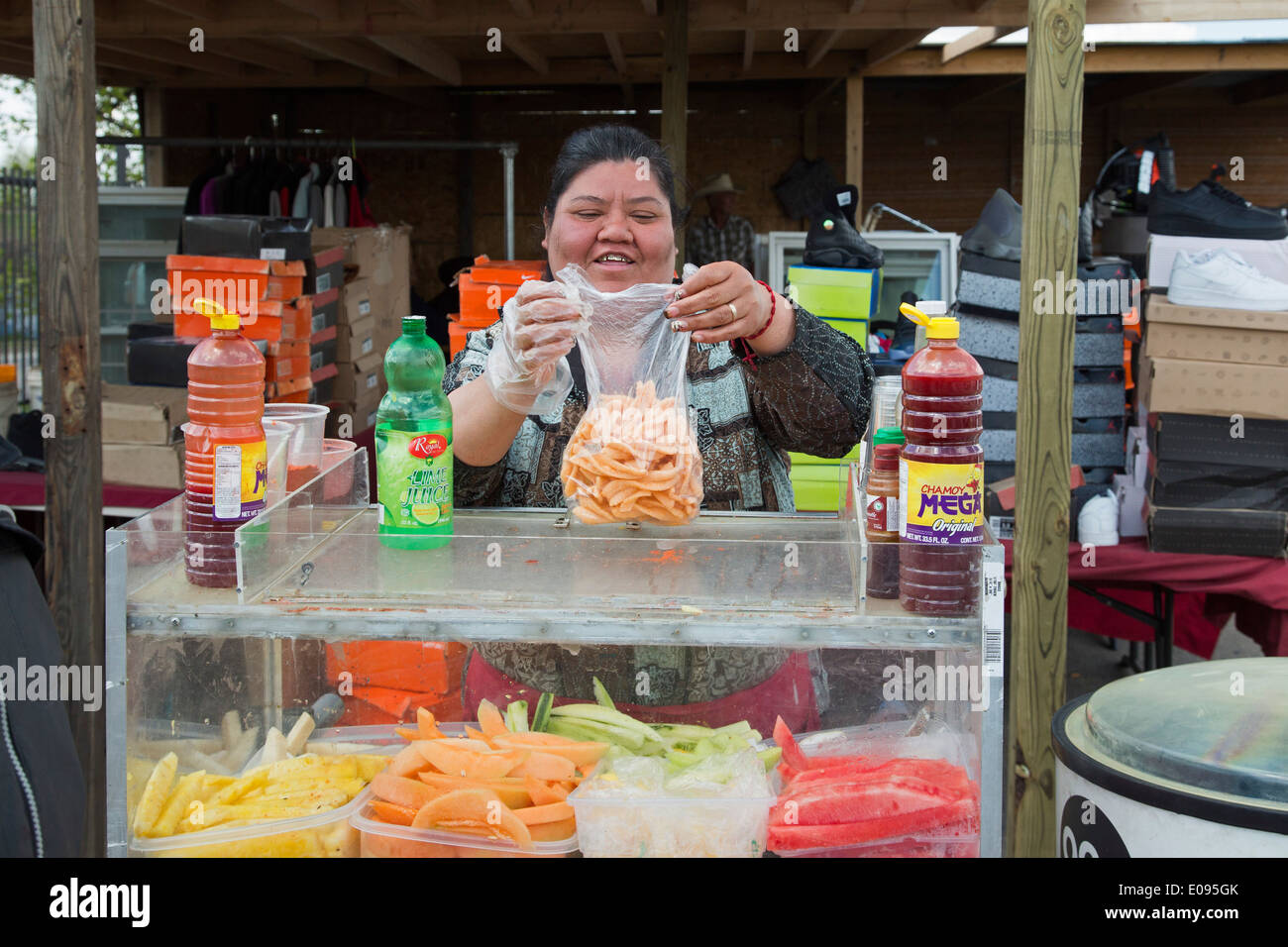Una donna ispanica vende frutta e spuntini in un esterno di mercato delle pulci a Detroit Mexican-American del vicinato. Foto Stock