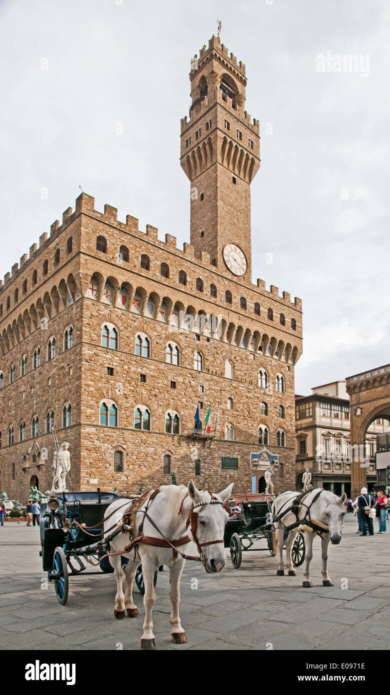 Il Palazzo Vecchio o Palazzo della Signoria in Piazza della Signoria Firenze Italia a cavallo guidati carrelli in attesa Foto Stock