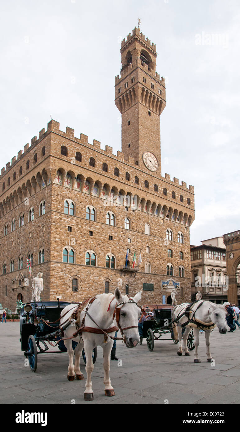 Il Palazzo Vecchio o Palazzo della Signoria in Piazza della Signoria Firenze Italia a cavallo guidati carrelli in attesa Foto Stock