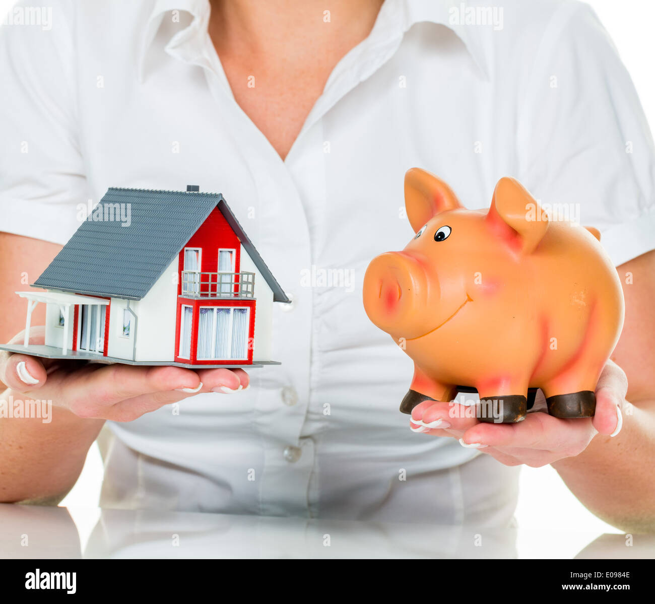 Una donna con una casa e un salvadanaio. Il diritto di un finanziamento per l acquisto di una casa., Eine Frau Mit einem Haus und einem Sparschwe Foto Stock