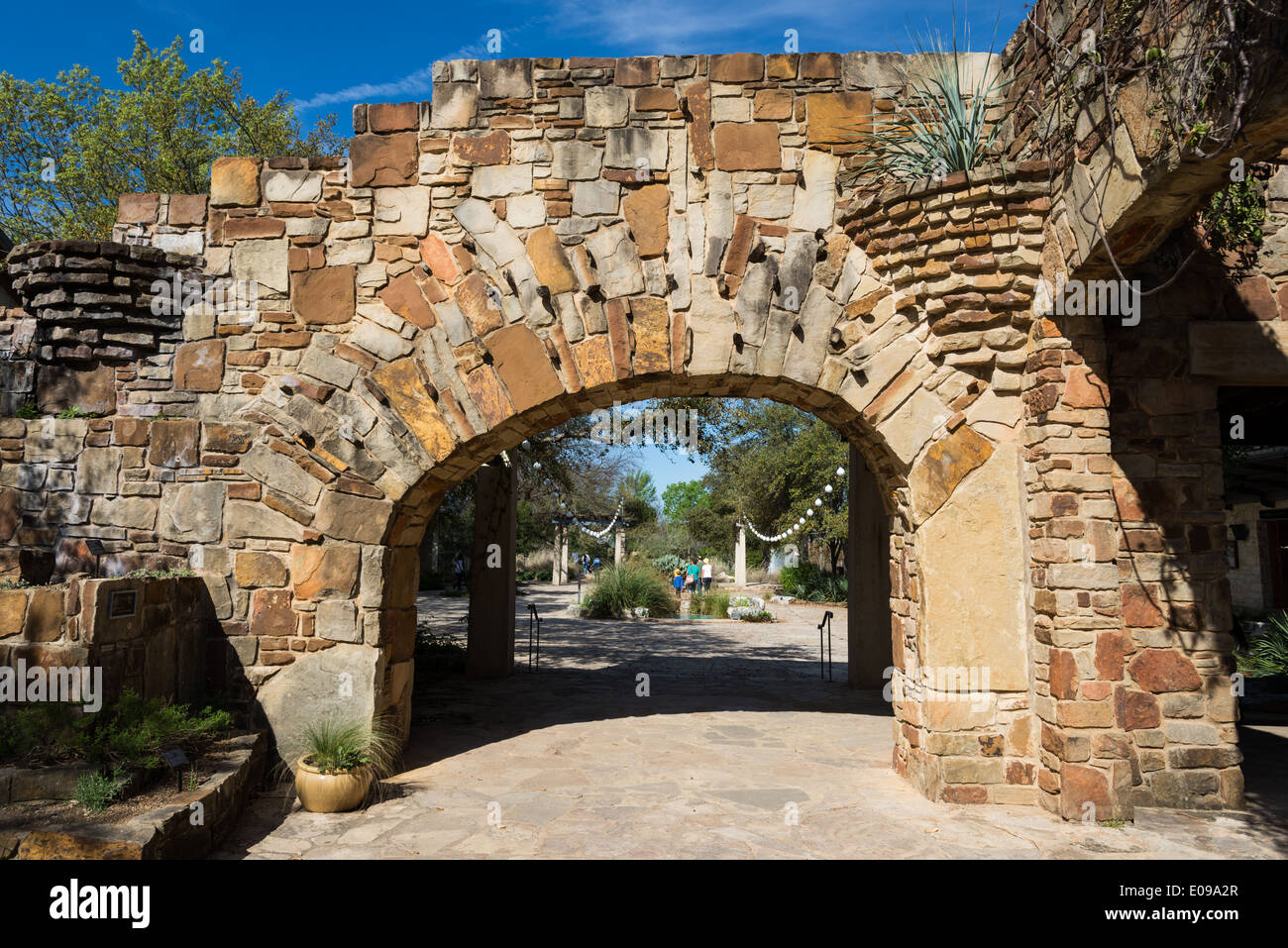 Porta arcuata di un muro di pietra al Lady Bird Johnson Centro di fiori selvaggi. Austin, Texas, Stati Uniti d'America. Foto Stock