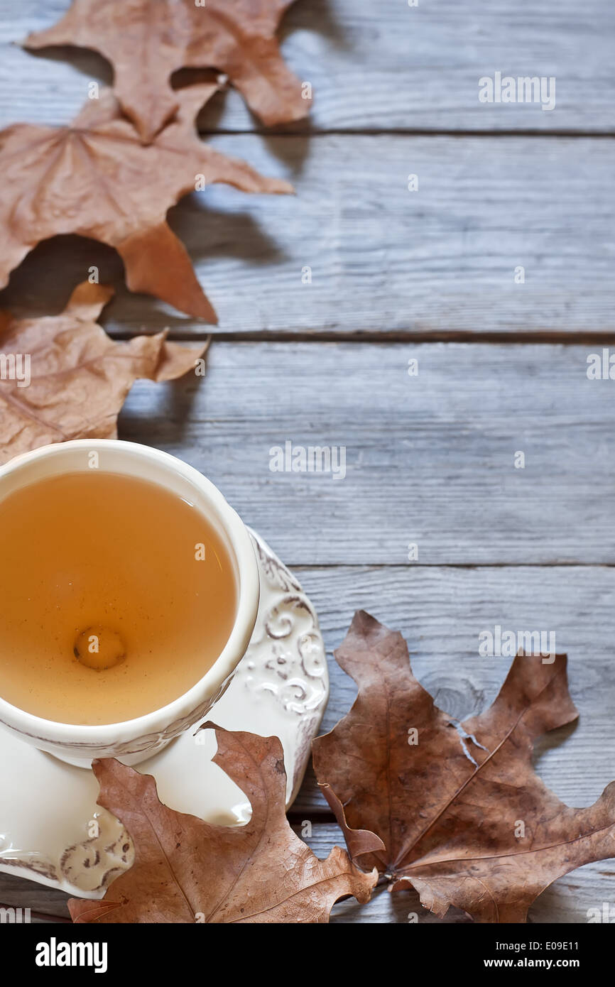 Il tè verde in tazze vintage sul tavolo di legno secco con foglie di autunno. Copia di sfondo spazio. Foto Stock