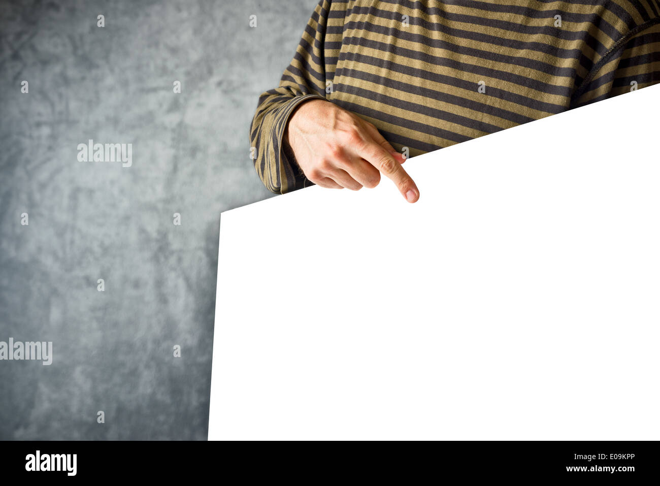 Uomo con poster di carta come copia di spazio per qualsiasi tipo di testo o grafica e puntando con il dito indice. Foto Stock