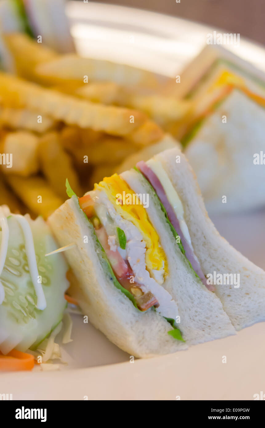 Deliziosa club sandwich con patatine fritte a cena Foto Stock