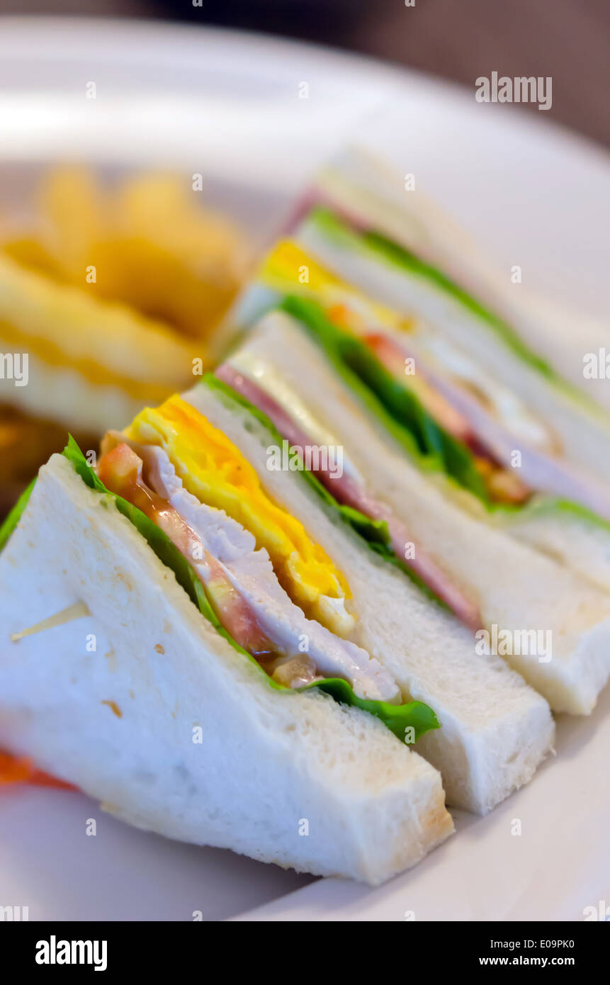 Deliziosa club sandwich con patatine fritte a cena Foto Stock