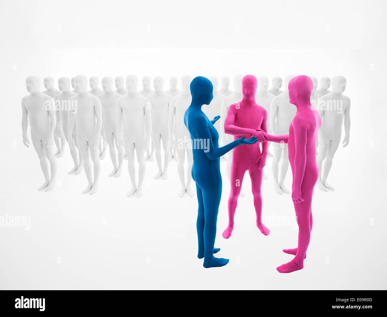 Una Donna vestita in tuta blu convince due uomini vestiti in rosa per agitare le mani davanti a una folla di persone vestite di bianco Foto Stock