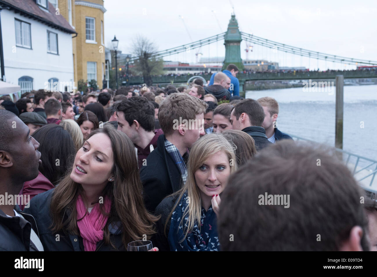 Gli spettatori sulla riva del fiume Tamigi a Hammersmith durante l annuale Oxford e Cambridge Boat Race. Foto Stock