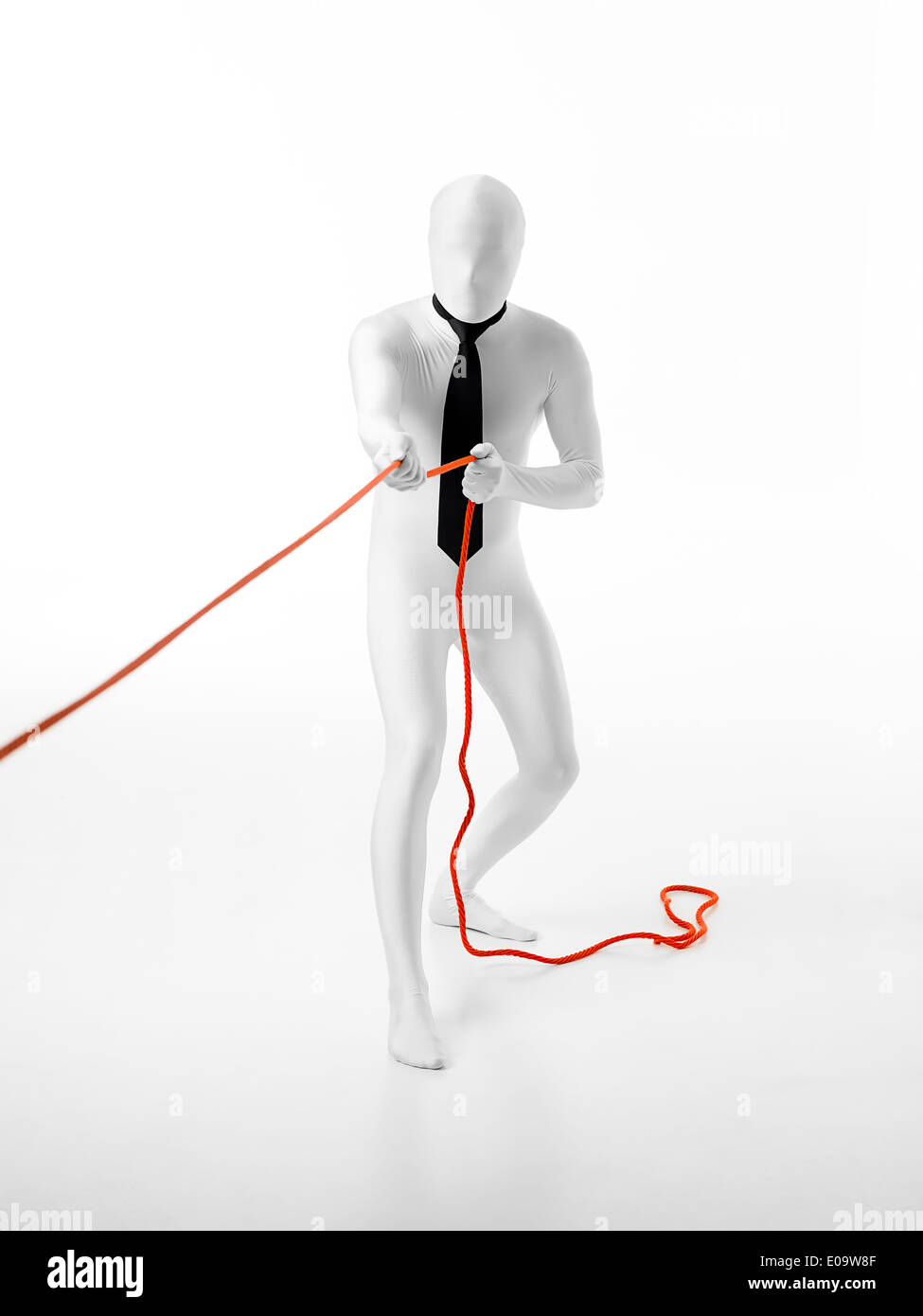 Imprenditore senza volto con black tie tira una corda arancione Foto Stock