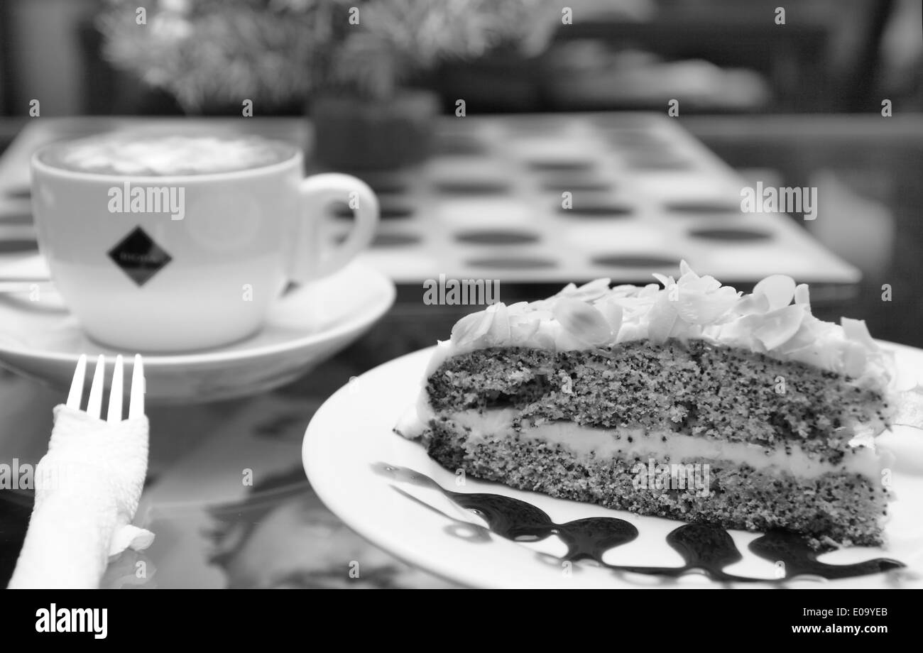 Il Cappuccino e semi di papavero torta sul tavolo all'esterno. Foto Stock